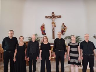 Membres de The Art of Music en vêtements de concert noirs dans une église